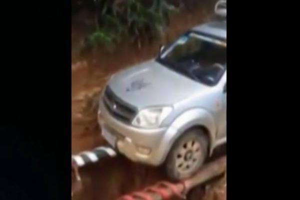 Brave-SUV-driver-crosses-collapsed-road-on-tree-trunk-chopstick-bridge