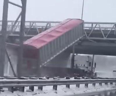 Semi-truck-with-raised-bed-collides-with-pedestrian-bridge